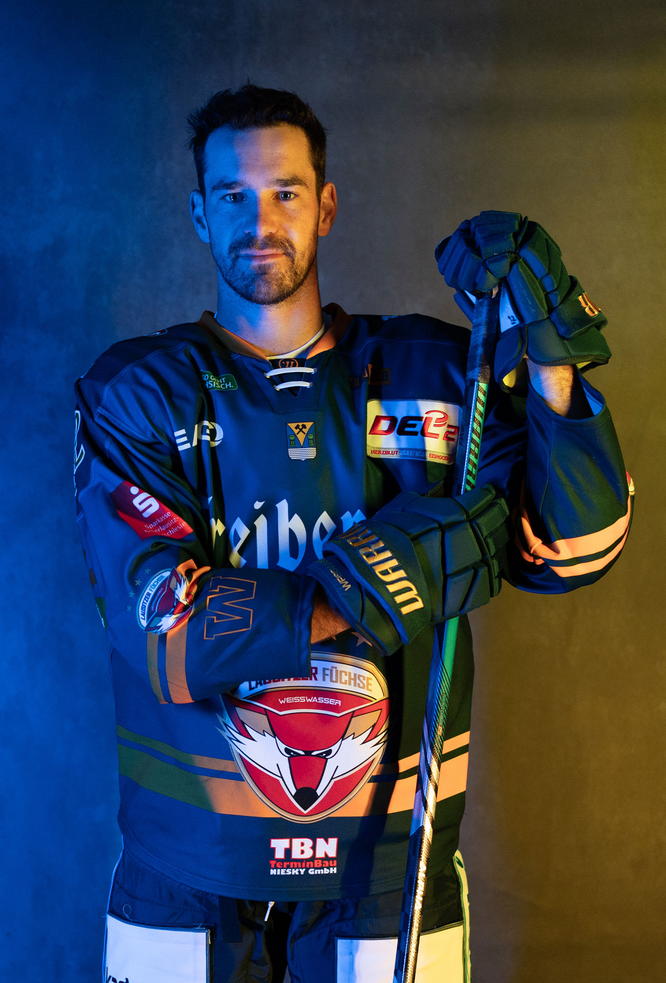 Jake Coughler in einer Pose mit Eishockeyausrüstung und Schläger