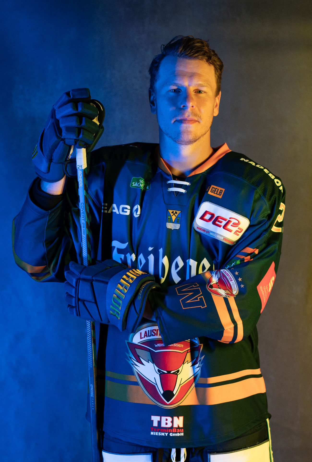 Lane Scheidl in einer Pose mit Eishockeyausrüstung und Schläger