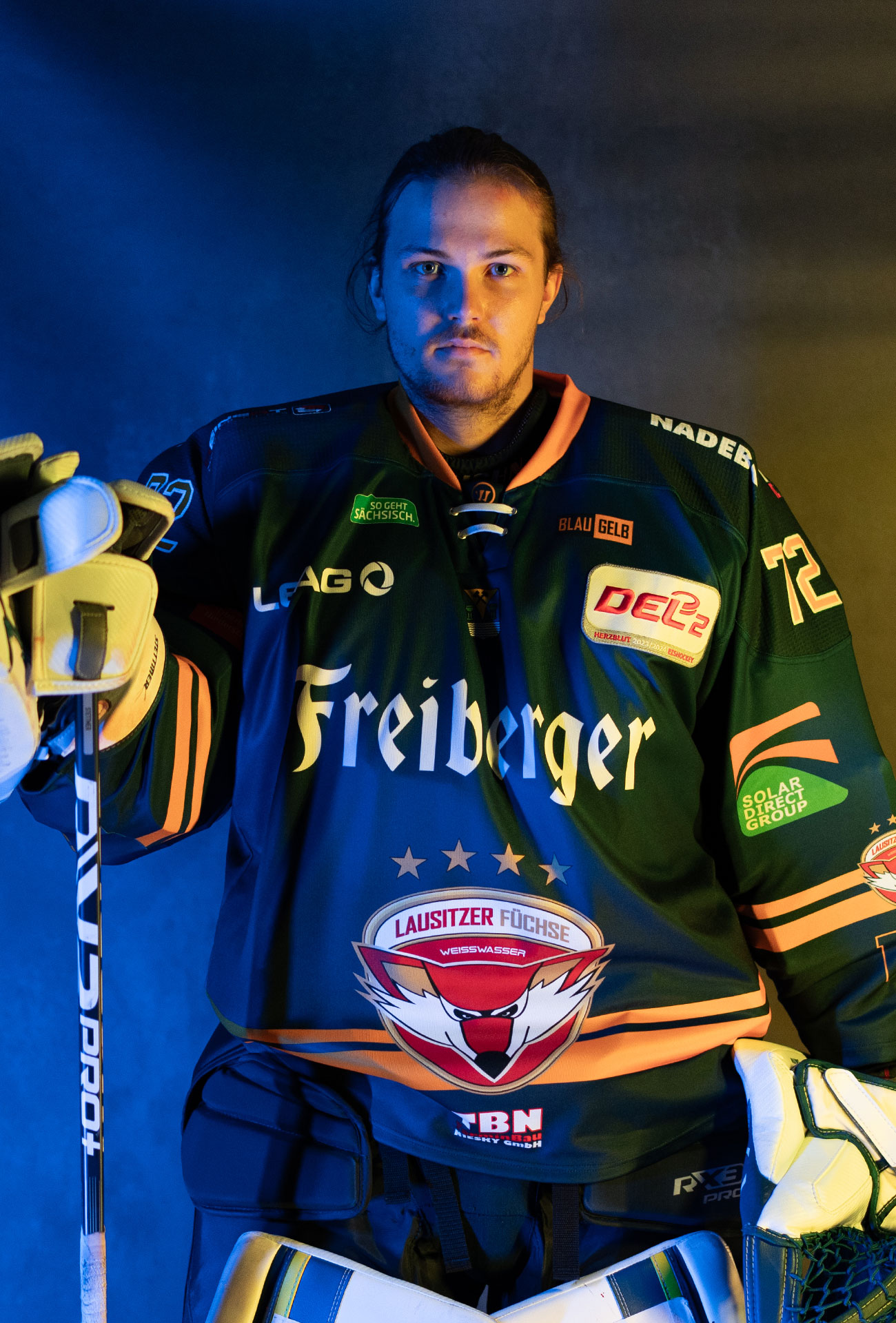 Jonas Stettmer in einer Pose mit Eishockeyausrüstung und Schläger