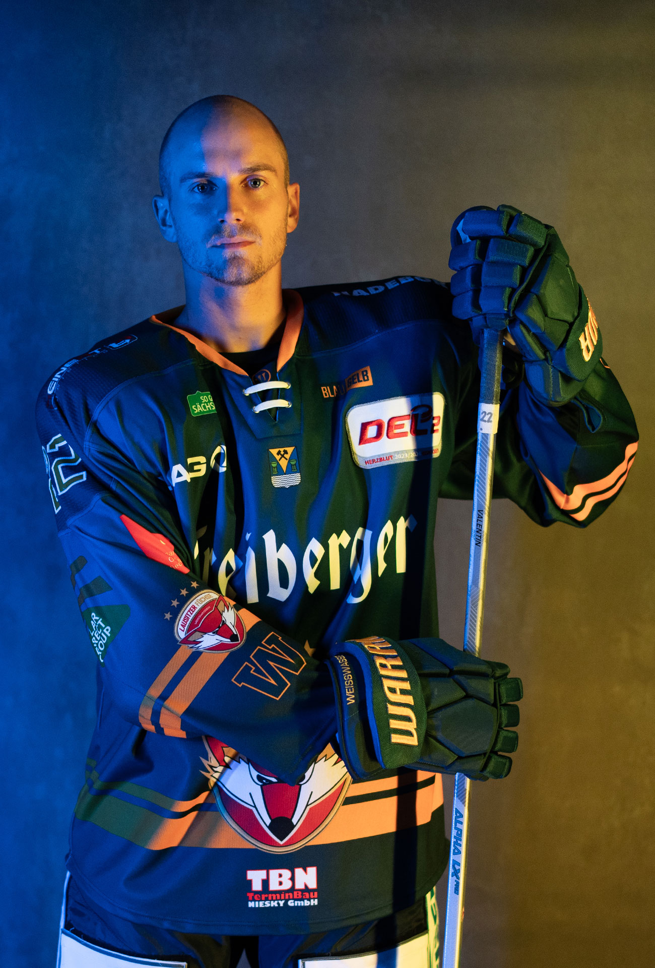 Eric Valentin in einer Pose mit Eishockeyausrüstung und Schläger