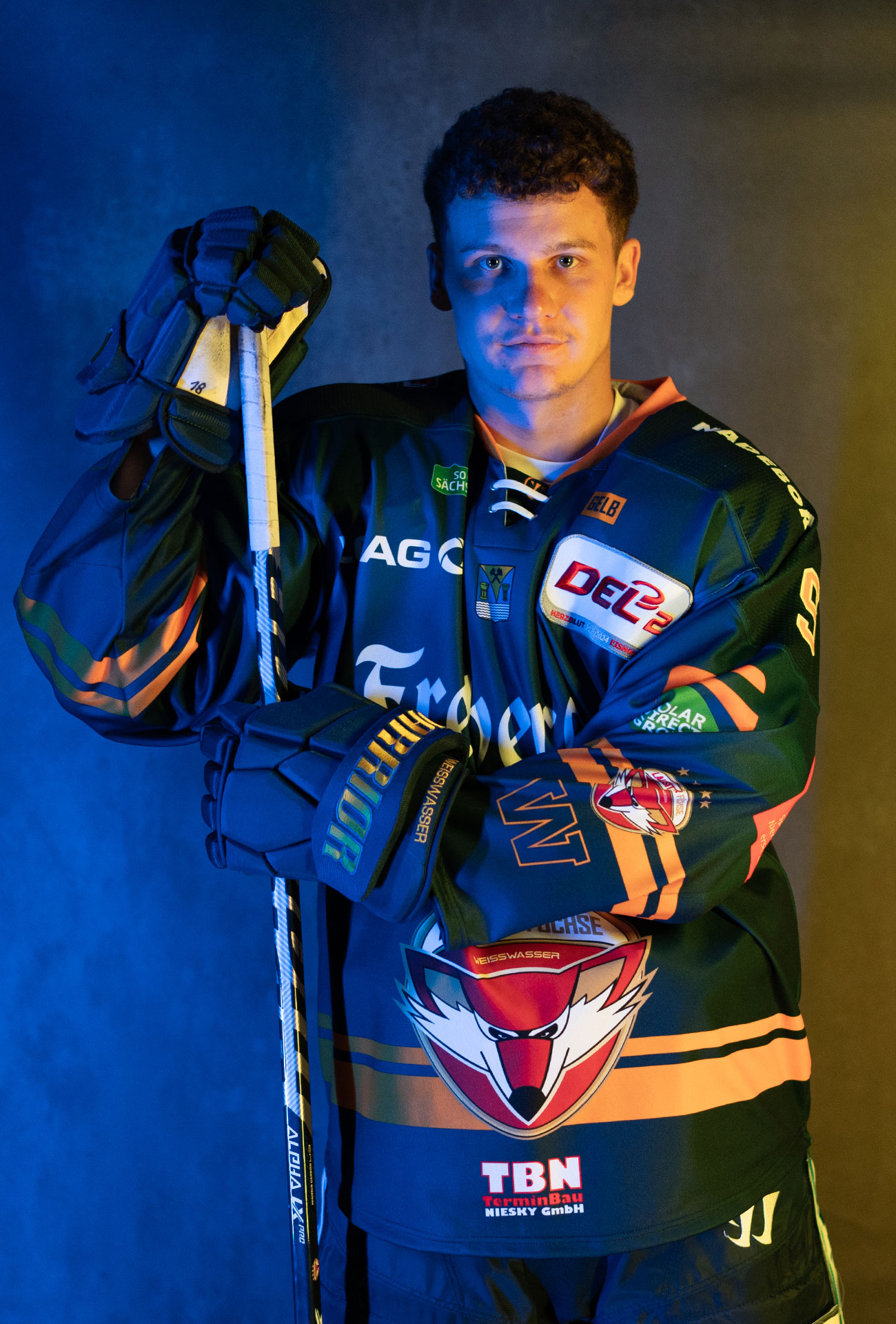 Julian Wäser in einer Pose mit Eishockeyausrüstung und Schläger